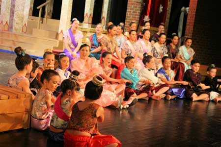 Mrs. Anna (Elaina Daoulas, senior) is 'Getting To Know You' - surrounded by the King's children and wives.