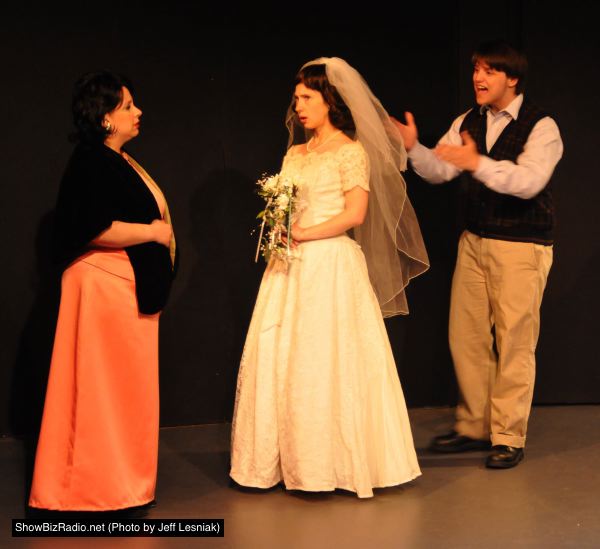 Benjamin Braddock (Zachary Hamilton) attempts to kidnap Elaine (Heather Martin) from her wedding, while Mrs Robinson (Rachel Duda) intervenes.