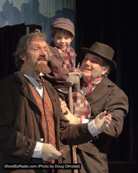 Mark Lee Adams (Charles Dickens), Cillian Farrell (Tiny Tim), and Elliott Bales (Scrooge)