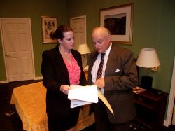 Accountant Karen Brown (Shirley Panek) shows Mayor Meekly (Ken Kienas) the irregularities in the city's financial records in her motel room during the police sting.