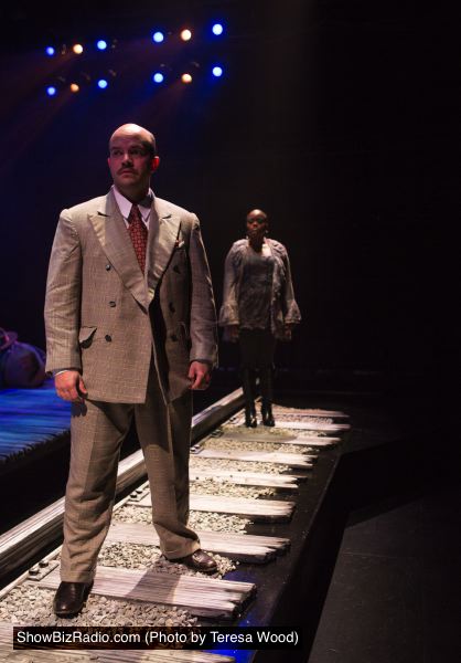 The Wealthy Man (Chris Sizemore) ponders a life-or-death choice under the eye of the Unknown Woman (Nova Y. Payton)