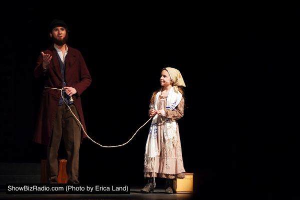 Tateh (Landon Fleischman) ties his Little Girl (Alyssa Herman) to him on a rope when they set out of New York City looking for work outside the tenements