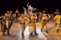 Kathleen Turner (center) as Mother Courage and the cast